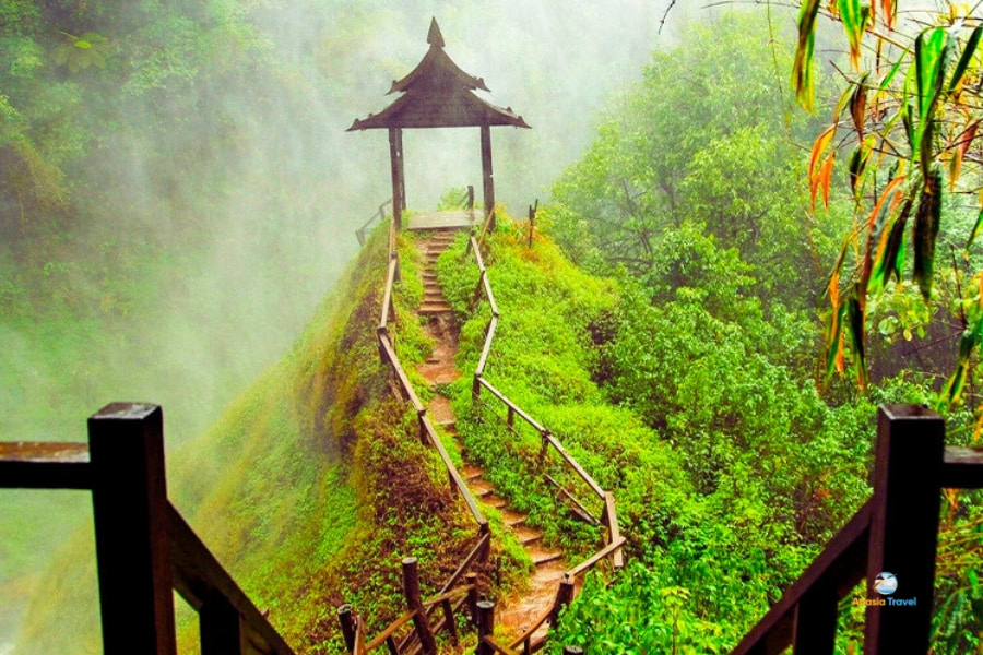 Misty view of Tad Yuang Waterfall with wooden pavilion in Laos – Auasia Travel